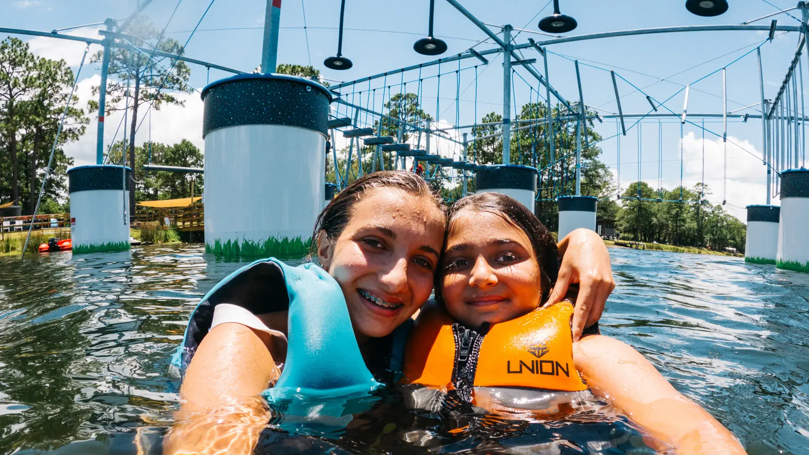 Two guests in the water under the ropes course
